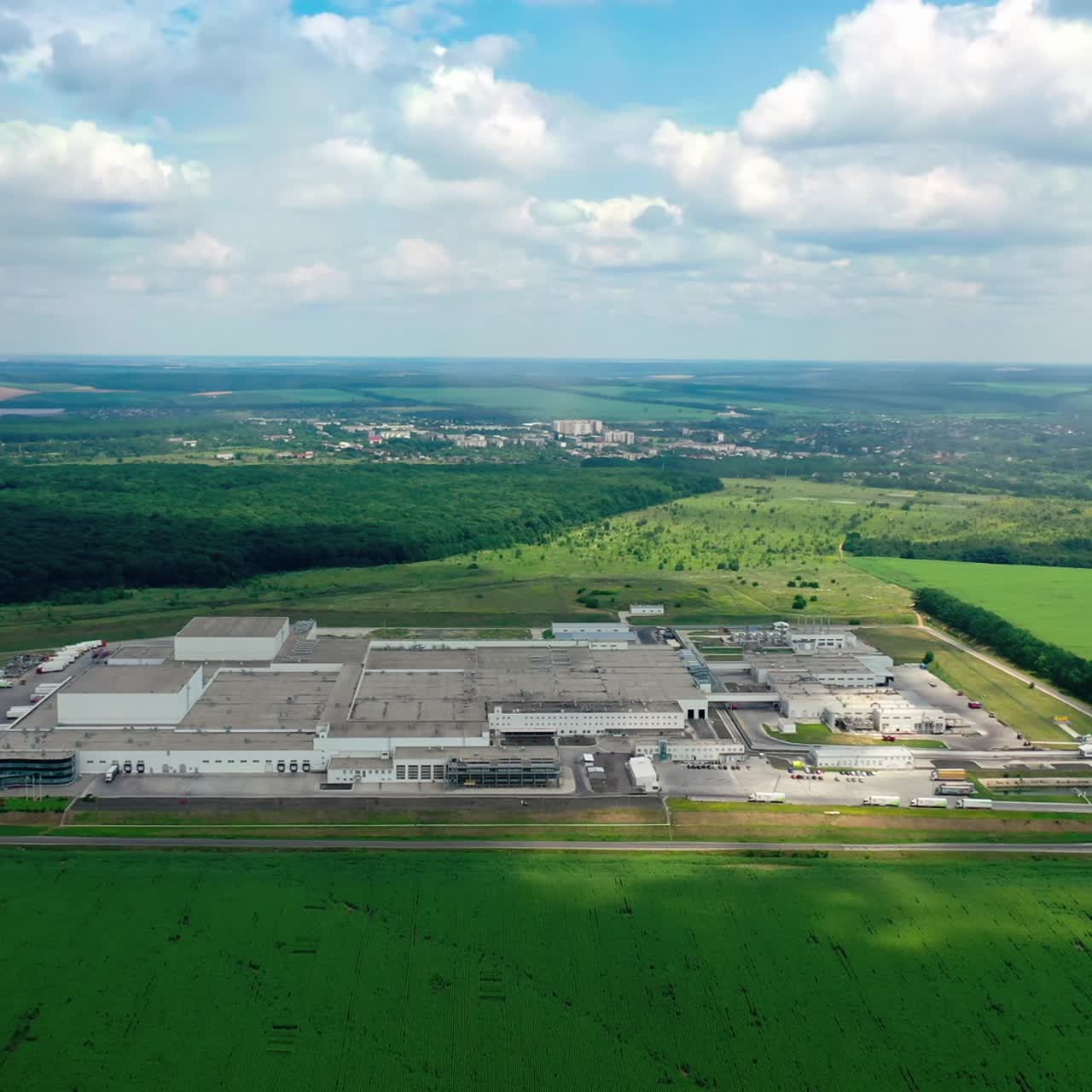 Industrial landscape. Large factory surrounded by green nature. Industrial plant on green field background. Aerial view