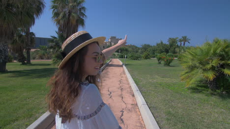 happy woman pointing towards a castle in a beautiful garden