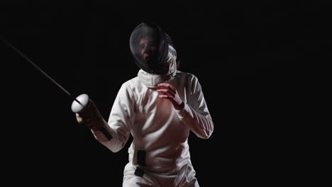 fencer in white uniform with black mask