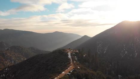 aerial shot of a highway in the middle of california mountains