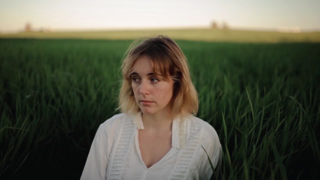 Romantische Frau in Vintage-Kleidung ruht auf einem Feld.