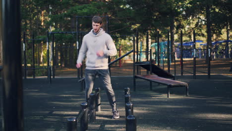 man doing jumping jacks at an outdoor gym