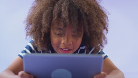 Studio-Portrait-Of-Boy-Using-Digital-Tablet-Against-Purple-Background