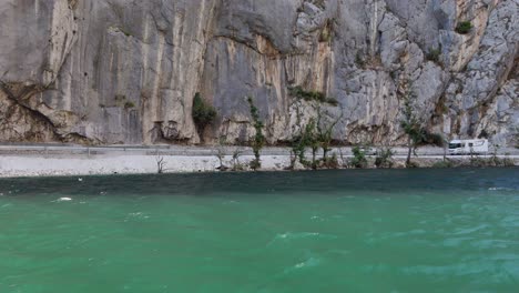 un coche conduce a lo largo de la orilla del río cetina en omis, croacia