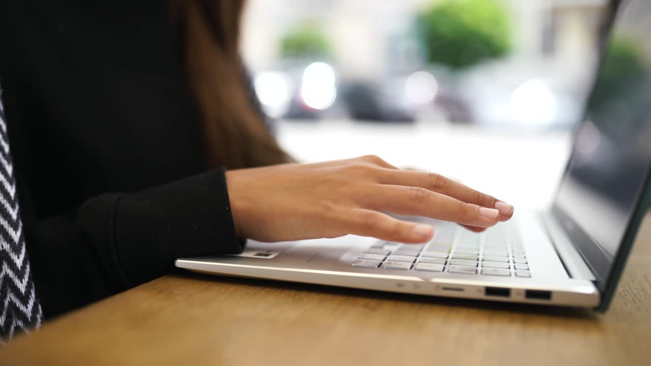 mujer trabajando en una computadora portátil en un café