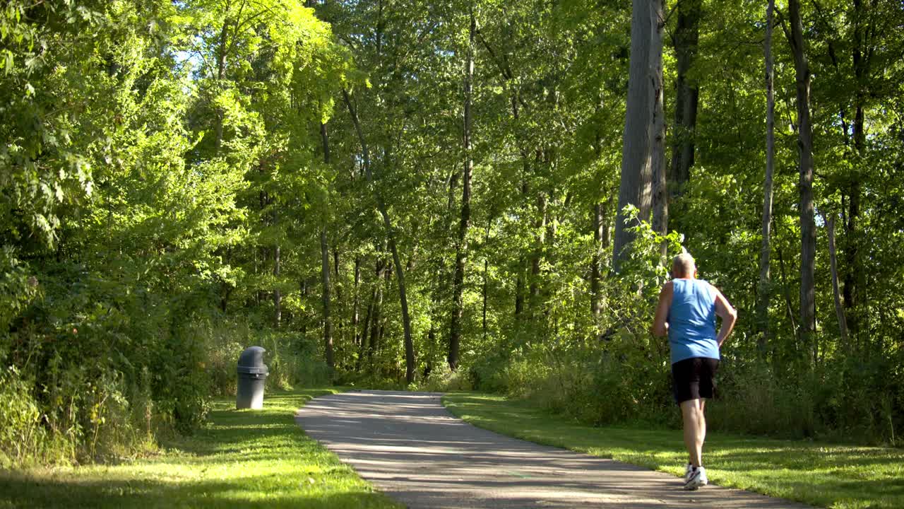 hombre sano haciendo su paseo por la tarde en el parque en una ruta de senderismo