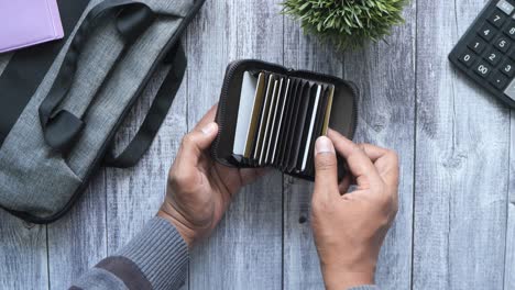 man holding a card holder with credit cards