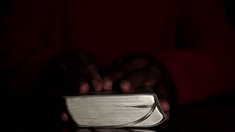 praying-to-god-with-hands-together-with-bible-and-cross-Caribbean-man-praying-with-black-background-stock-video