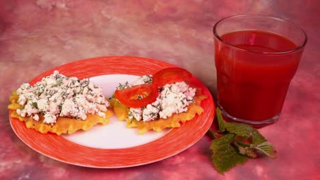 preparación de sándwich vegetariano con queso cottage, eneldo, tomates y aceitunas, jugo de tomate.