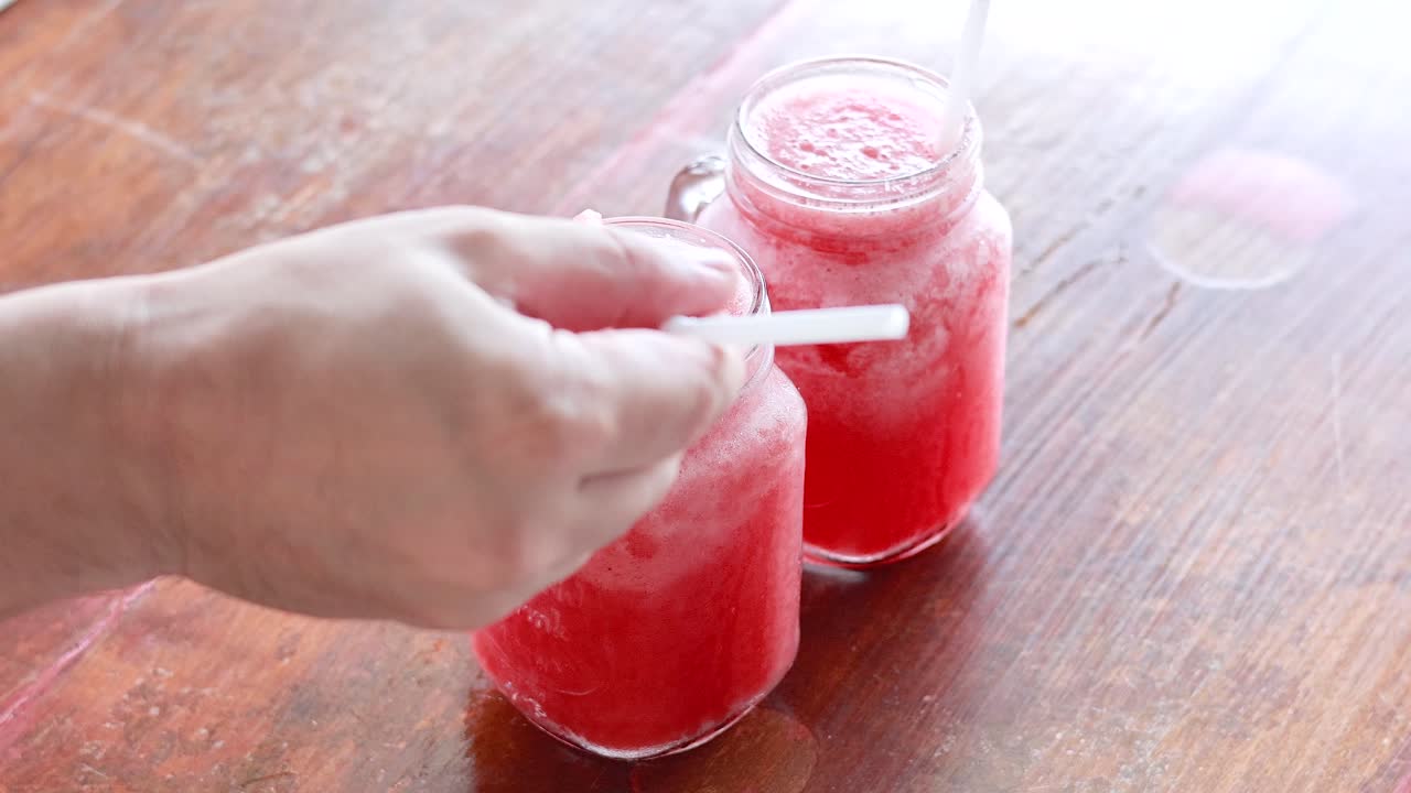 나무 테이블 에 수박 음료 를 는 손