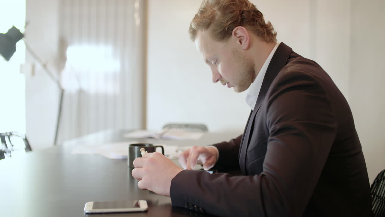 Young Businessman Using Smartphone at Office Desk