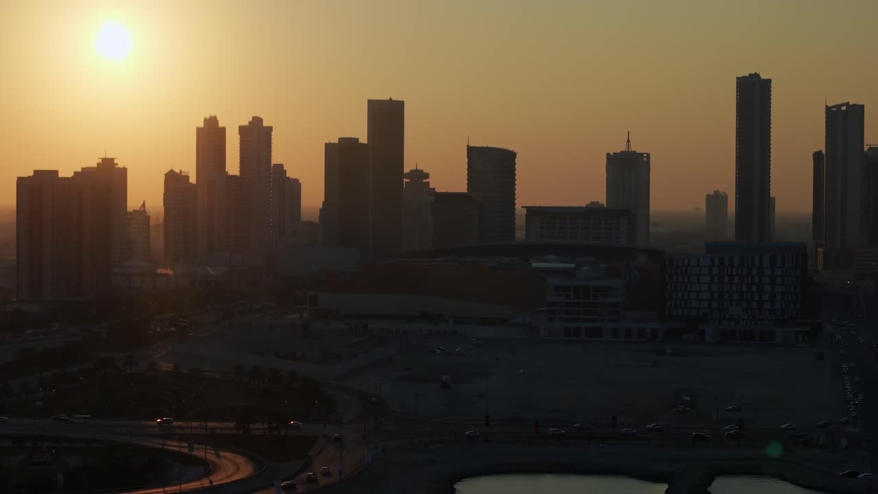 Sanabis district, Manama, Bahrain. Aerial view of highrise buildings backlit by setting sun