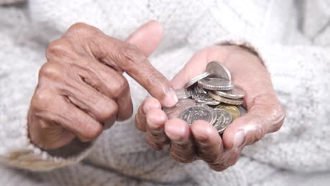 manos de ancianos con monedas