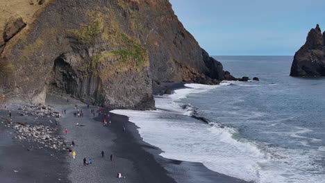 at the black sand beach, the mountain's grandeur, the beach's calmness, and people's joy come together in a captivating experience