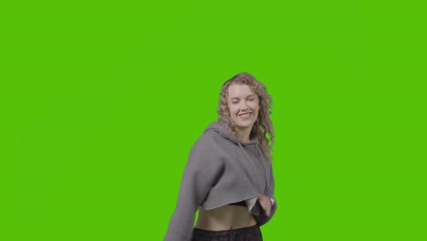 studio shot of young woman having fun dancing against green screen 18