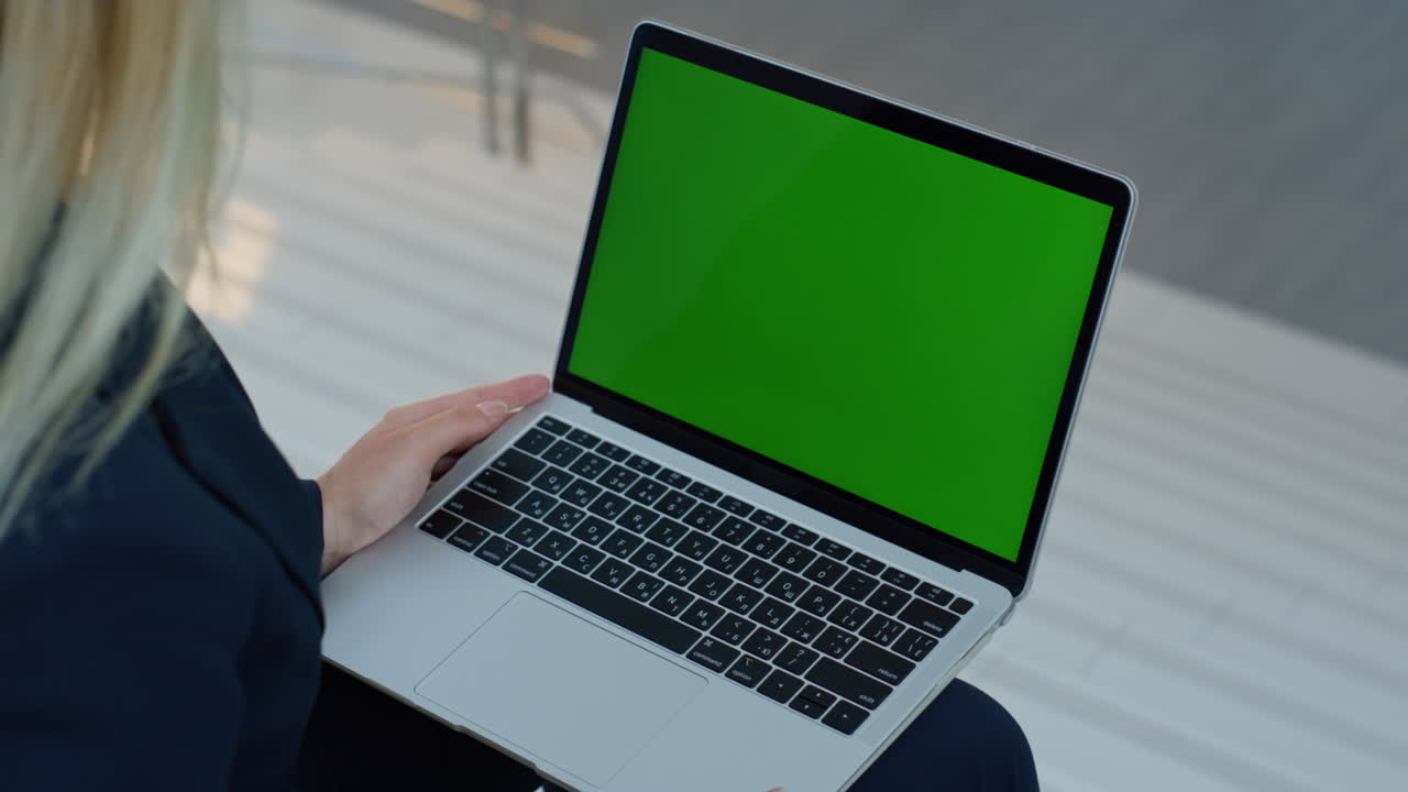 Dipendente che legge un'e-mail su un laptop con chroma key seduto in un ambiente di lavoro aziendale, primo piano