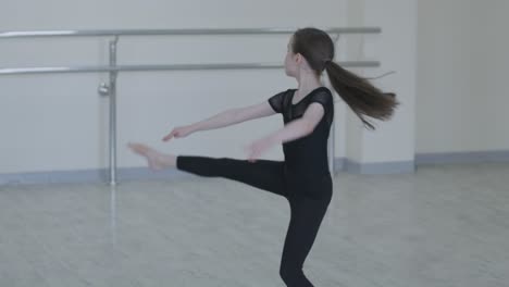 young ballerina practicing dance moves in studio