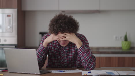 joven con un teléfono inteligente en sus manos. hombre de negocios moderno o estudiante en la oficina de casa. profesional independiente en el trabajo. joven estudiante estudia en casa con una computadora portátil y usa un teléfono inteligente