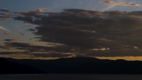lapso de tiempo de cielo nublado al atardecer sobre montañas interminables y vistas al lago en el paraíso