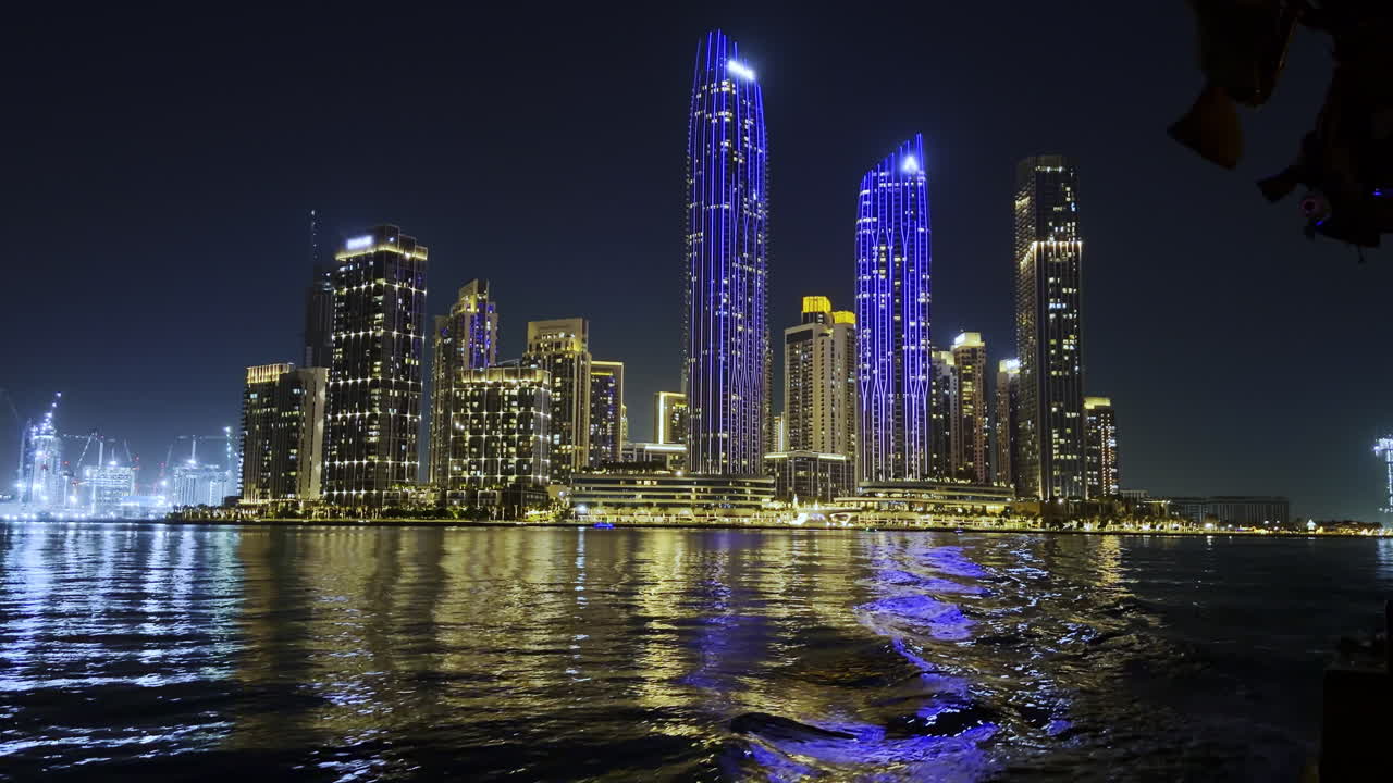 Skyline illuminato della città di Dubai di notte con riflessi magici di lusso sul lungomare del creek