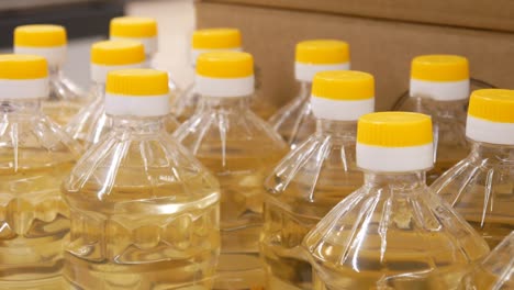 close-up of many bottles of sunflower oil and a male hand takes one