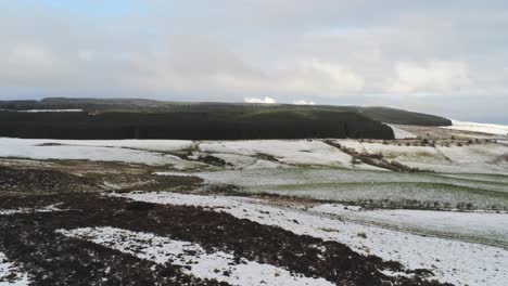 snowy rural winter valley countryside aerial pan right slow across agricultural farmland landscape