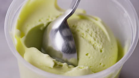 Scooping Green Ice Cream from a Tub