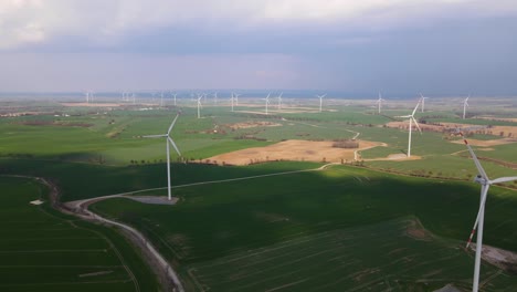 Parque-Eólico,-Muchos-Molinos-De-Viento,-Tierras-De-Cultivo,-Campos,-Disparo-De-Drone,-Plan-Total