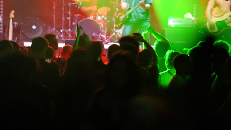 energetic crowd dancing at a vibrant music concert with colorful lights and blurred motion