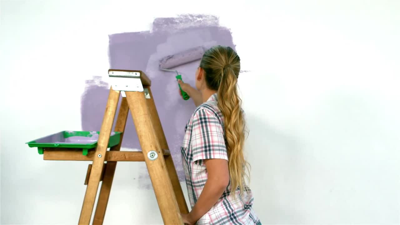 chica bonita redecorando una pared con pincel
