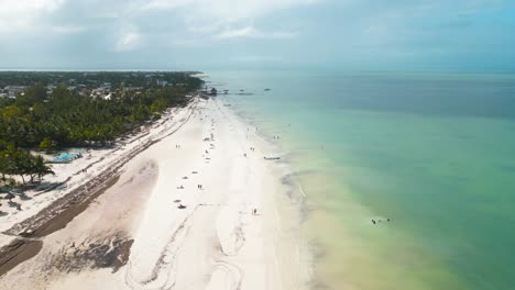 Wide-angle-aerial-drone-view-of-the-busy-sandy-white-beaches-of-the-tropical-island-of-Holbox-in-Mexico-during-a-really-hot-sunny-day-shot-in-4k