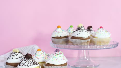 sweet cup cakes served on the table for party with white cream and crumbs