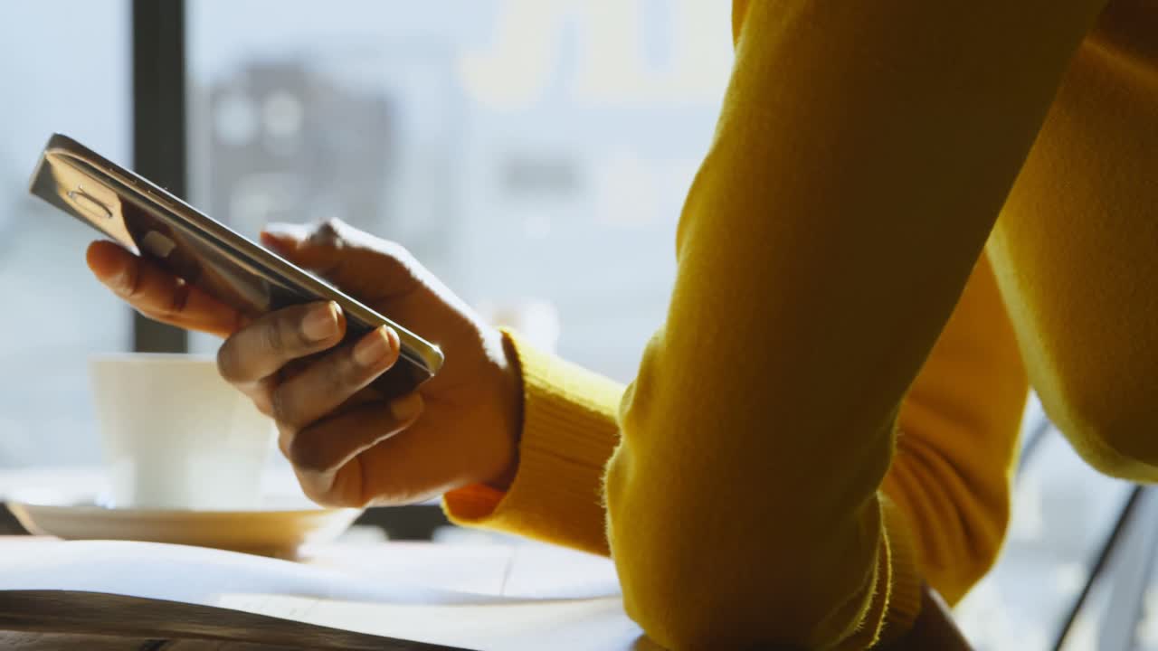 Kvinde bruger mobiltelefon på café 4k