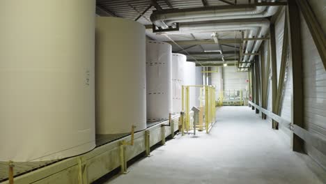 giant paper rolls transferred through conveyer belt in paper towel manufacturing factory in france