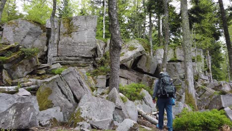 male hiker arriving at the rock formation named volzemer steine while hiking the popular long-distance trail westweg through the black forest in southern germany