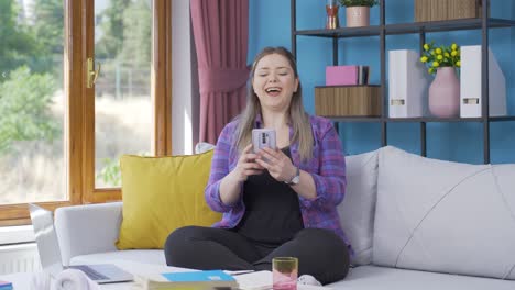 Young-woman-smiling-at-phone-message.