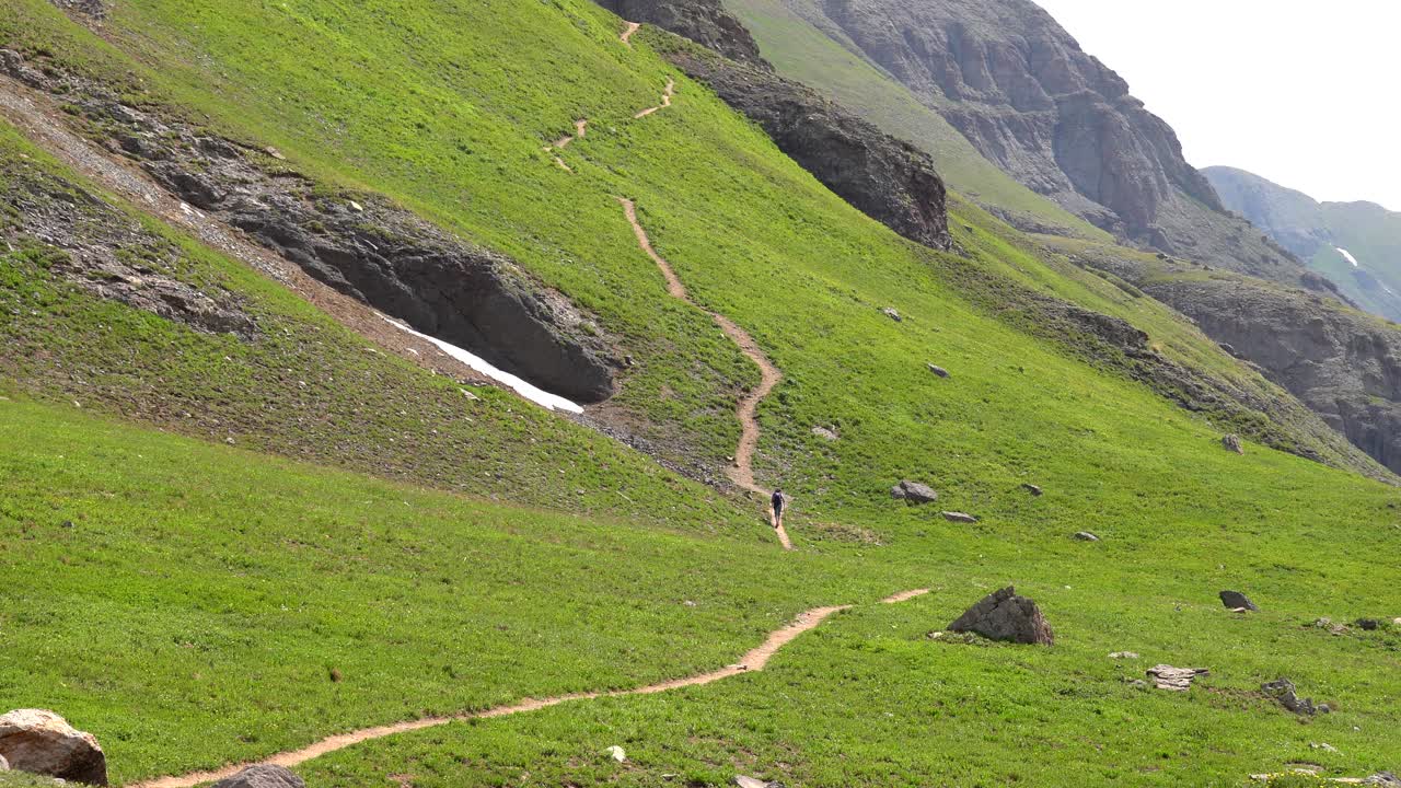 Woman hiking a steep trail in the San Juan Mountains of Colorado