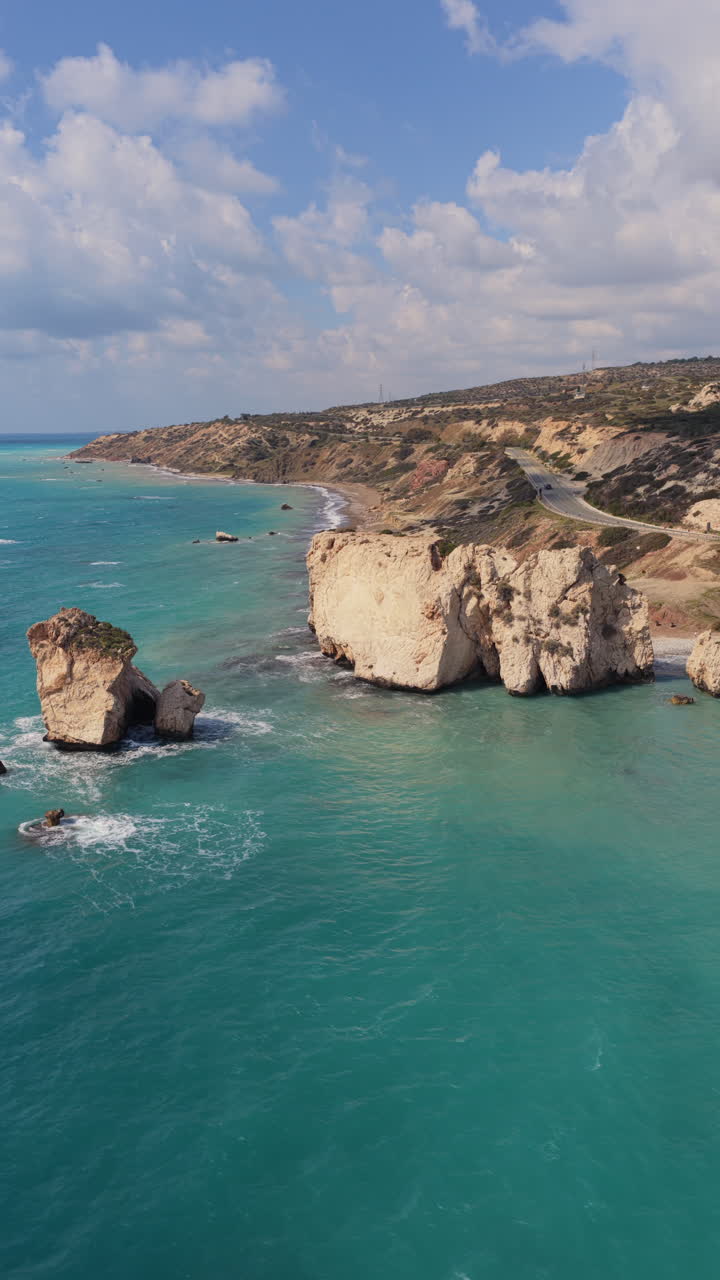 Aerial drone view of Aphrodite's Rock near Paphos, Cyprus, surrounded by turquoise Mediterranean waters. Vertical