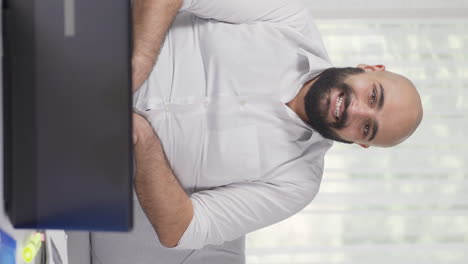 Vertical-video-of-Home-office-worker-man-looking-at-camera-with-excitement-and-feeling-happy.