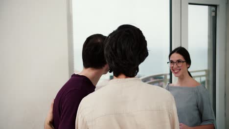 attractive male couple viewing a property together with agent