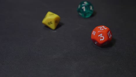 recogiendo rol jugando dados coloridos de la superficie negra, cámara lenta