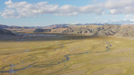 mongolian ger tents with bayan-olgii city background, altai mountains, aerial view