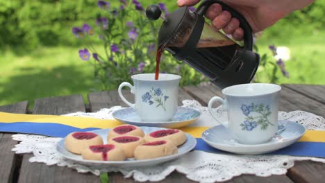 Hands take served presso coffee and jam cookies, raspberry caves
