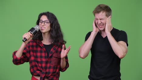 una pareja joven cantando juntos.