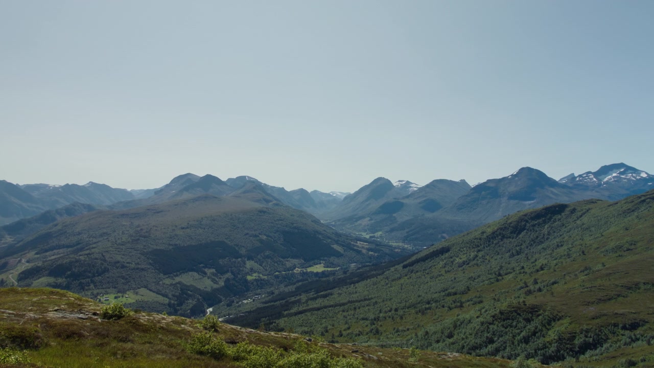 Cahaya musim panas yang terang menyingkapkan dataran tinggi Norwegia yang berlapis-lapis melandai ke cekungan hijau yang jauh di antara puncak-puncak yang membulat.