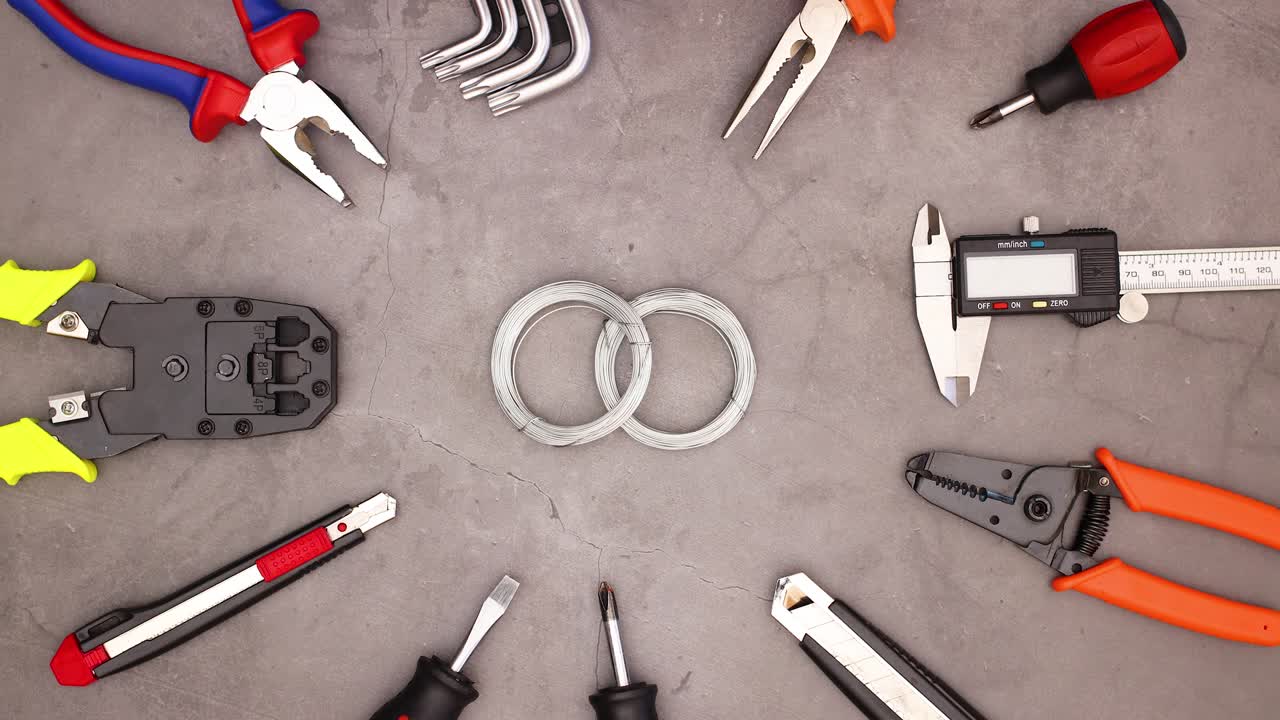 건설 도구는 작업 테이블에 있는 금속 와이어를 둘러싸고 나타납니다.