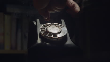 person using 1950s black retro-styled telephone in smoky dark room. a conceptual drama shot, close up