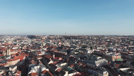 Cinematic-fly-over-Prague-city-red-Old-town-rooftops-during-blue-sky-day