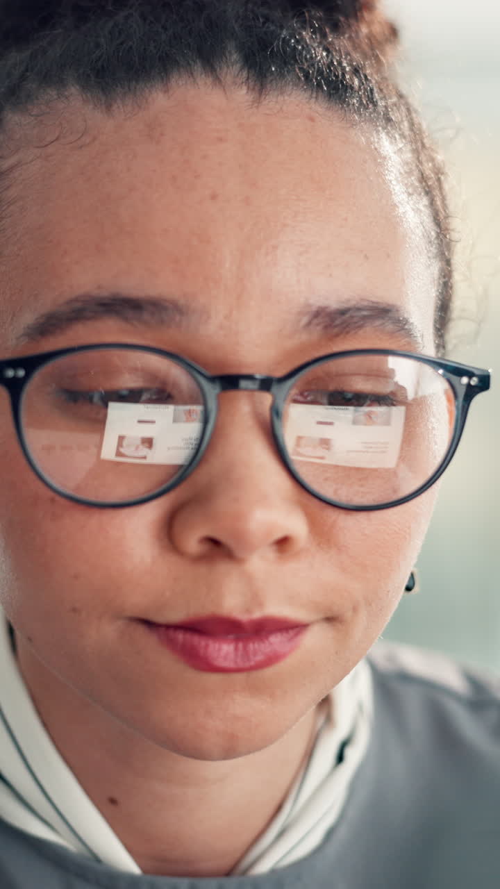 Donna concentrata con gli occhiali che lavora al computer