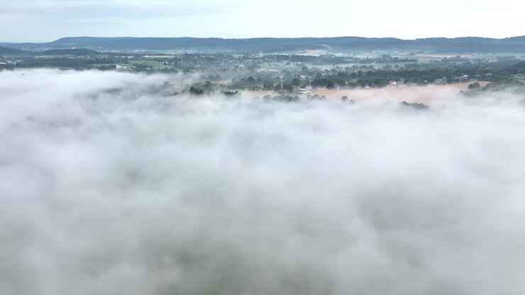 Et smukt luftfoto af det tågedækkede landskab i det tidlige morgenlys